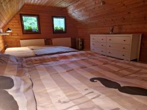 Un dormitorio con una cama grande en una cabaña de madera. en Koča na Pikovem, en Črna na Koroškem