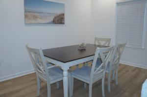 Townhome near beach and The Wharf Amphitheater! في شاطئ أورانج: طاولة طعام مع أربعة كراسي و لوحة +6 صور