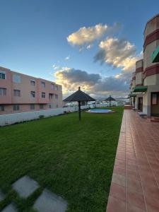 un prato con un ombrellone al centro di un edificio di Golden Apartment a La Garita