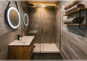 a bathroom with a shower and a sink and a mirror at 21 Gramm Das Verborgene mit Tiefgarage in Sasbachwalden +23 photos