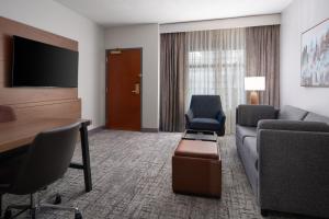 Embassy Suites by Hilton Franklin Cool Spring في فرانكلين: غرفة في الفندق مع أريكة وطاولة وكراسي