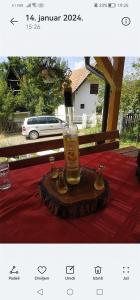 Vikendica Dunav i SAVA في دونيي ميلانوفاتس: زجاجة ويسكي موضوعة على طاولة مغطاة بمفرش طاولة