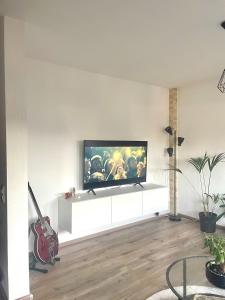 リューネンにあるGemütliche & voll ausgestattete Stadtwohnungの壁に薄型テレビが取り付けられたリビングルーム