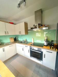 リューネンにあるGemütliche & voll ausgestattete Stadtwohnungの白いキャビネットとシンクのあるキッチン