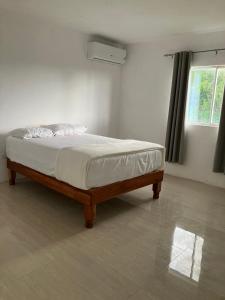 een bed in een witte slaapkamer met een raam bij So Suite, Negril with seaview in Negril