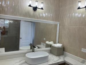 een persoon die een foto neemt van een badkamer met een wastafel bij So Suite, Negril with seaview in Negril +14 foto's