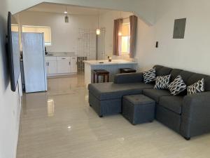 een woonkamer met een bank en een keuken bij So Suite, Negril with seaview in Negril