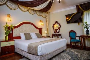 a bedroom with a large bed and a blue chair at Gya Hoteles in Arequipa