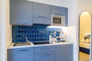 a blue kitchen with a sink and a microwave at Villa Emma Exclusive in the Historic Center-Sorrento Coast in Vico Equense