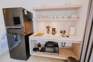 a small kitchen with a sink and a microwave at 605 Tower Downtown Cabo in Cabo San Lucas