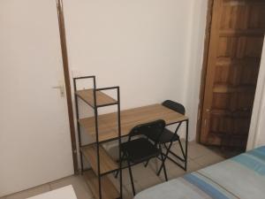 a desk and two chairs in a room with a bed at Chambre sur FDF in Fort-de-France