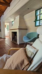 ein Wohnzimmer mit einem Kamin und 2 Stühlen in der Unterkunft Casa quinta Cerrito Colorado in Junín