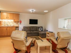 a living room with a couch and two chairs at Hay Loft in Anstruther