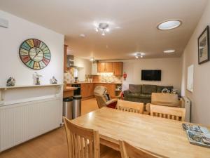 a living room with a dining room table and a kitchen at Hay Loft in Anstruther