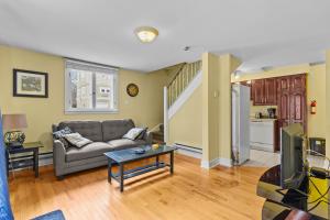 een woonkamer met een bank en een tv bij Midstream Loft 2BR Parking W&D in St. John's