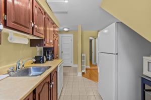 een keuken met een spoelbak en een koelkast bij Midstream Loft 2BR Parking W&D in St. John's +10 foto's