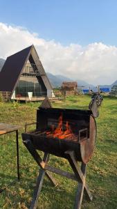 a barbecue grill in a field with a building in the background at Misty Colina in Kottakamboor