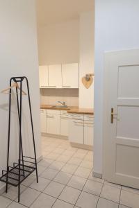 uma cozinha com armários brancos e uma escada preta em Stylish Old Town Apartment with Infrared Sauna em Linz