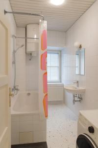um banheiro com chuveiro, banheira e pia em Stylish Old Town Apartment with Infrared Sauna em Linz