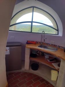 una cucina con lavandino e finestra ad arco di Cabañas Las Luciérnagas a San Javier Altre 8 foto