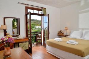 a bedroom with a bed and a desk and a mirror at Vagia Traditional, Aegina Island in Vaia