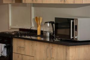 IJ Apartments في ندولا: طاولة مطبخ مع ميكروويف وموقد