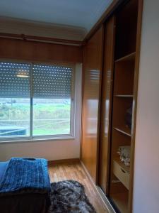 Un dormitorio con una cama y una ventana grande. en Deluxe Room Santarém, en Santarém