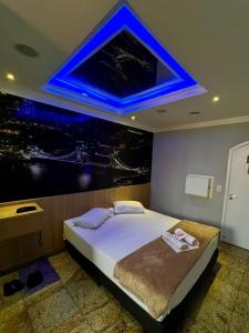 a bedroom with a large bed with a blue ceiling at Motel Segredos (Adults Only) in Guarulhos