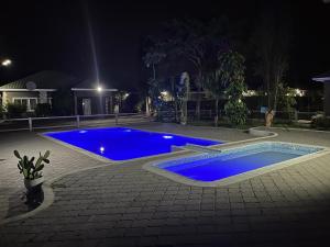 IJ Apartments في ندولا: مسبح في ساحة بالليل