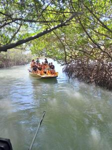 um grupo de pessoas em um barco em um rio em camping do point lá na barra em Amontada mais 1 fotografia