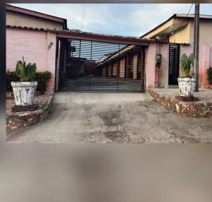 a garage with a black gate and two potted plants at Residencial Silvas AP 02 in Macapá