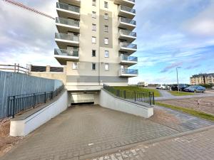 Szpitalna Residence & Garage في سووالكي: مبنى كبير وامامه موقف سيارات