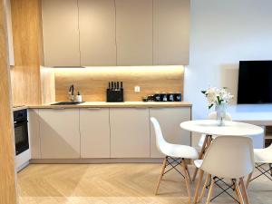 Szpitalna Residence & Garage في سووالكي: مطبخ مع طاولة وكراسي بيضاء