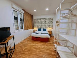 een slaapkamer met een bed met blauwe kussens en een ladder bij Hola Rooms in Madrid