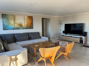 Una sala de estar con un sofá y un televisor. en Departamento completo en San Carlos de Bariloche, Argentina, en San Carlos de Bariloche