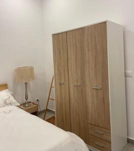 La perle de la marsa في المرسى: غرفة نوم مع خزانة خشبية بجوار سرير