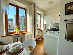 a kitchen with a table and a sink and a counter top at Spacious Old Town Apartment, 3 Rooms, Free Parking, Sleeps up to 7 in Kaunas