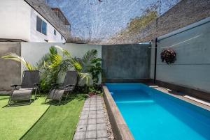 a backyard with a swimming pool and two chairs at Private Pool & Jacuzzi Family House, Teques in Tlatenchu +38 photos