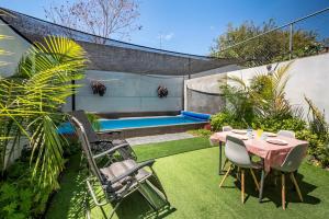 a backyard with a table and chairs and a pool at Private Pool & Jacuzzi Family House, Teques in Tlatenchu