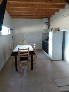 una cucina con tavolo, sedie e frigorifero di JAS departamento a General Acha