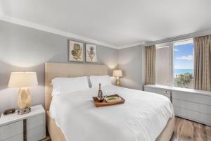 a bedroom with a large white bed with a tray on it at Marco Beach Ocean Resort 910 in Marco Island +43 photos