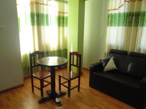 a living room with a table and chairs and a couch at Hostal Campestre Casa Blanca in Chucuito