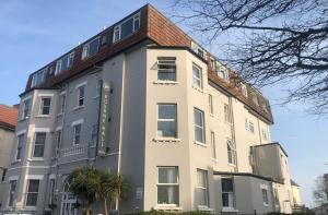 a large white building with a red roof at Royal House by Bourne Hall in Bournemouth