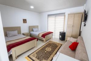 a living room with two beds and a couch at La MAISON DU VAL in Jbeil