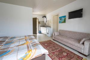a living room with a bed and a couch at La MAISON DU VAL in Jbeil +1 photo