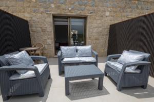 a group of chairs and a table and a chair and a table at La MAISON DU VAL in Jbeil