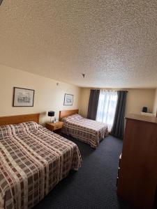 a hotel room with two beds and a window at Discovery Inn in Yellowknife +19 photos
