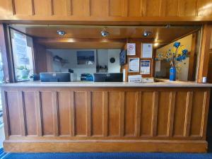 a wooden bar with two computers on top of it at Royal House by Bourne Hall in Bournemouth