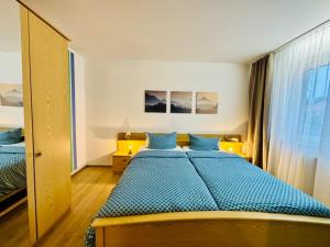 a bedroom with a bed with blue sheets and a window at NEU Apartmenthaus-Usedom Familie Stopp Kajüte 7 - Balkon - strandnah in Kölpinsee