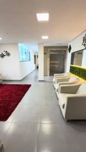 een wachtkamer met banken en een rood tapijt bij Hotel Mais Lazer in Joinville